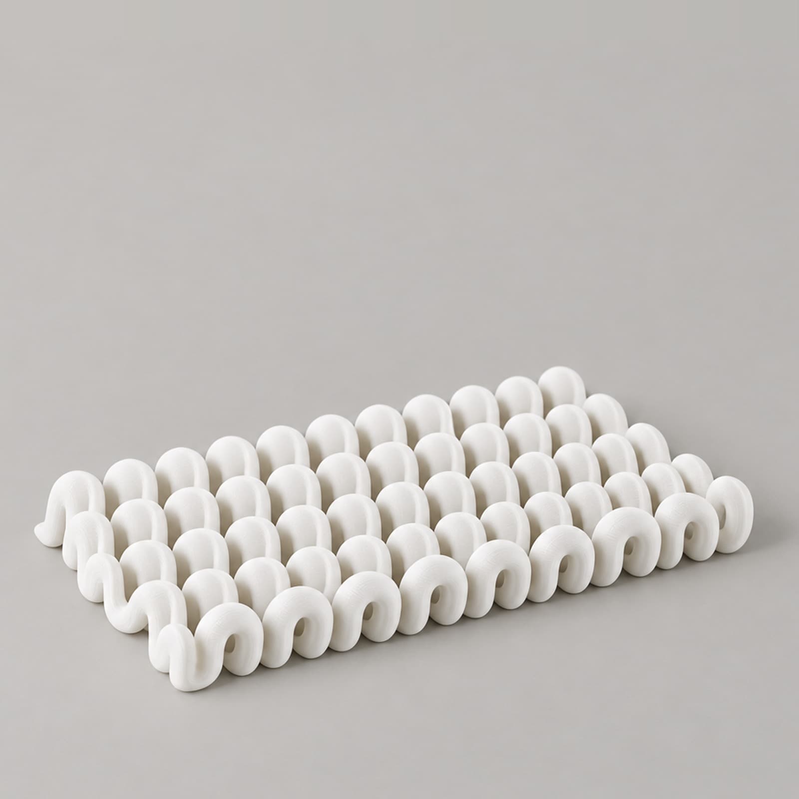 Ghirigoro – flache Stiftablage aus wellenförmigen Rundrohren aus dem 3D-Druck